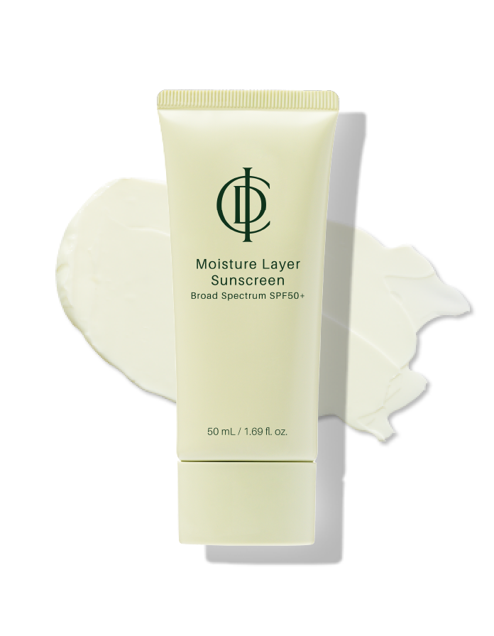 ICD Moisture Layer Sunscreen — pale green tube beside a swipe of white sunscreen texture on a white background