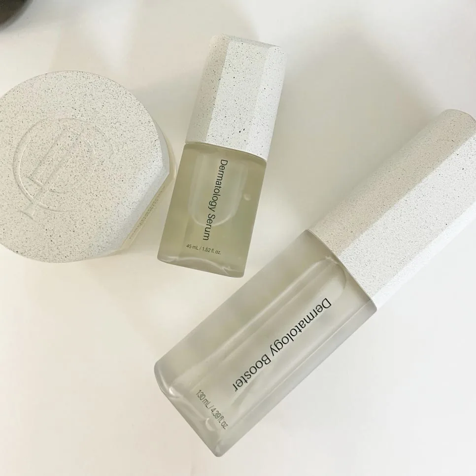 Flat lay of the Dermatology Cream, Serum and Booster on a white surface